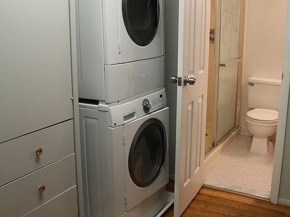 Primary custom closet with laundry and entrance to full bath with shower.