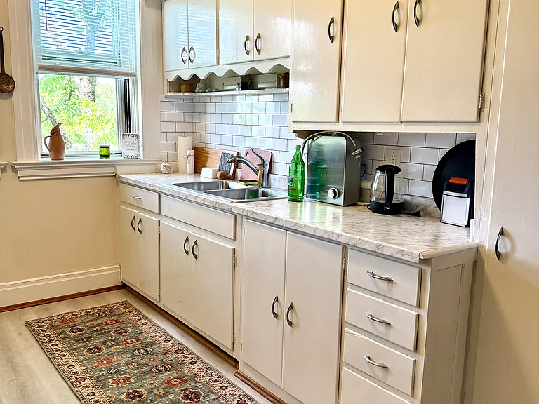 This view shows the updated countertop and backsplash. The wood cabinets provide ample storage space.