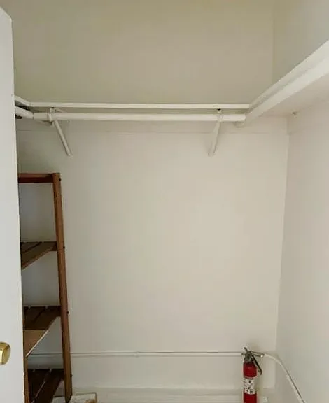 Large walk in closet with shelves and lots of space for hanging clothes and storage