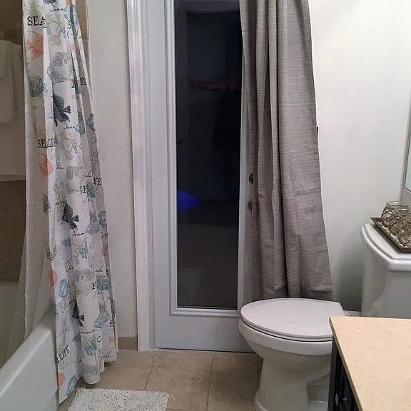 Guest bathroom with tub/shower combo, door and to outside pool area. Located between guest bedrooms and off of family room.