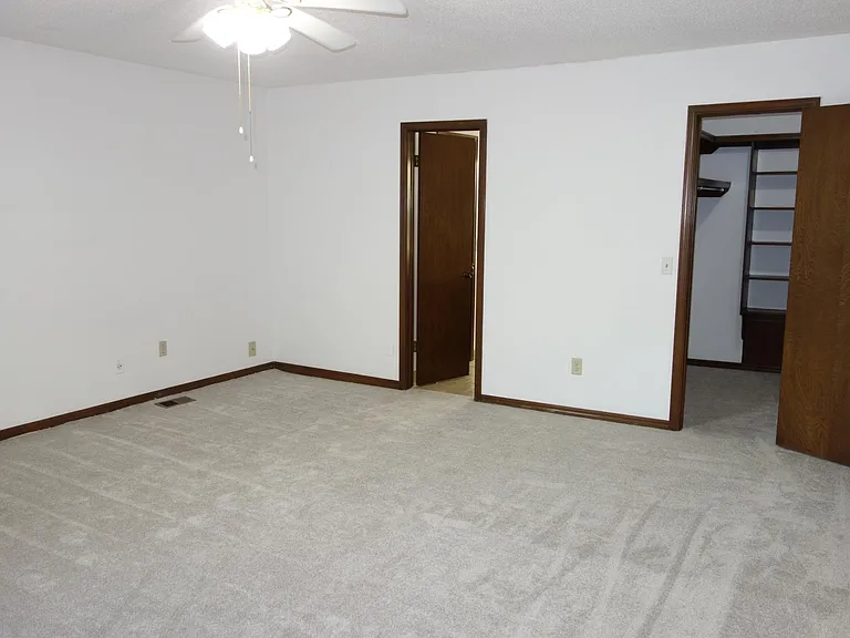 Large master bedroom walk-in closet on right and master bath entry on left.