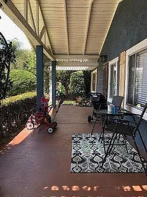 Large front porch looking to front grassy yard and street