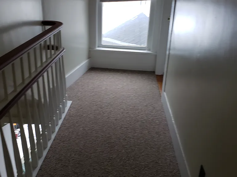 Hallway running to the front of the building. 2nd bedroom is on the right just before the window.