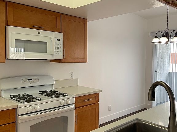 Kitchen with dining area to the right with balcony view