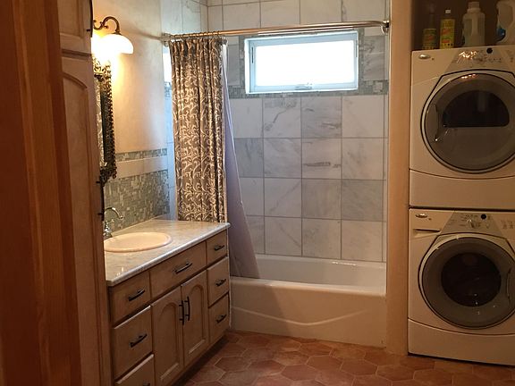Marble tile in shower and backsplash, antique lighting above sink, W/D in unit
