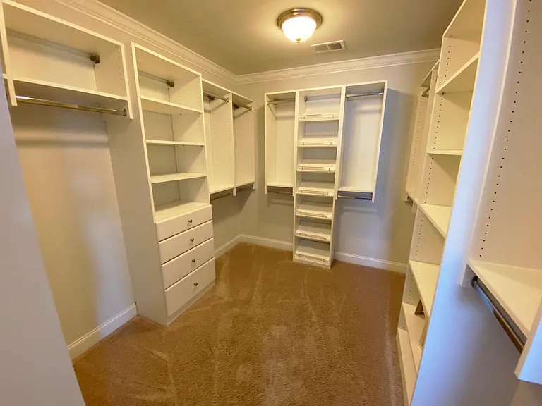 Beautiful built-in closet organizers in the large master bedroom walk-in closet