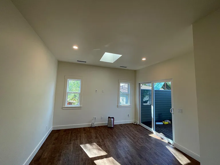living area with skylights, hookups for wall-mounted TV, access to private deck