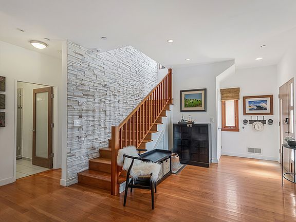 Steps headed upstairs with front door entry closet to the right