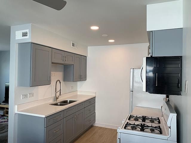 Completely renovated kitchen with Quartz tops, Grey Shaker cabinets, new refrigerator (to be delivered end of July), new microwave, and newer stove.