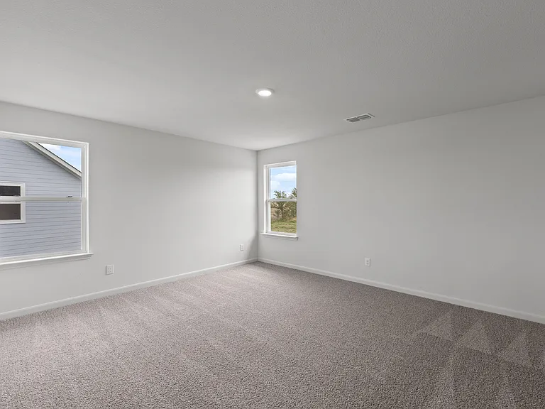 The spacious master bedroom has two windows that lets in natural light and backyard views.