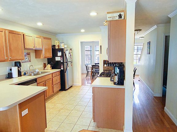 Open concept living flows into kitchen with stainless appliances, gas stove, and *dishwasher*