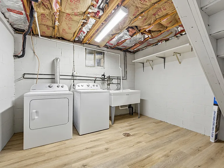 Laundry room equipped with a brand new washer, dryer, and double-bowl laundry tub.
