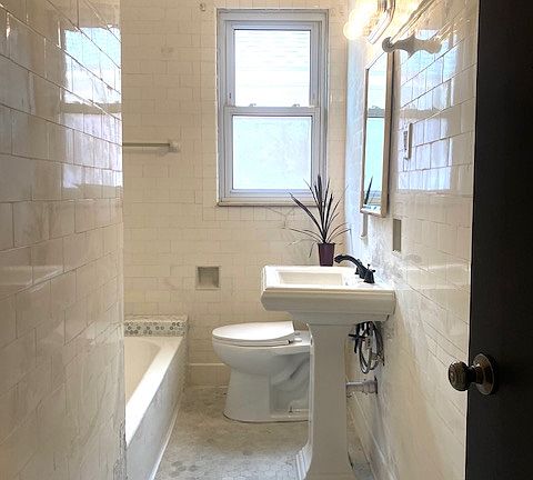 Main bathroom with brand new fixtures throughout features a rain shower head.
