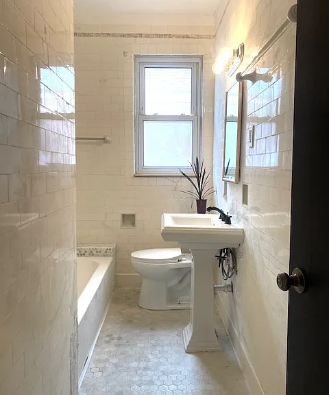 Main bathroom with brand new fixtures throughout features a rain shower head.
