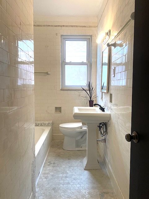 Main bathroom with brand new fixtures throughout features a rain shower head.
