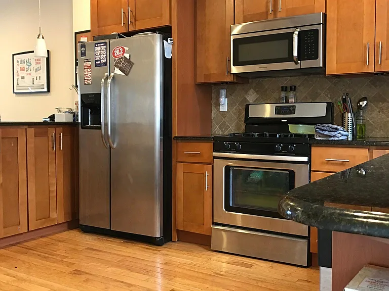 Sleek kitchen with stainless steel appliances, granite countertops, and breakfast bar seating