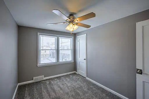 Grey walls and carpet in a bedroom.