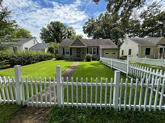 White picket fence around large front yard.
