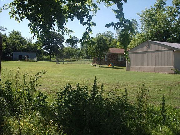 at property line looking back you see garage, side of house and small barn