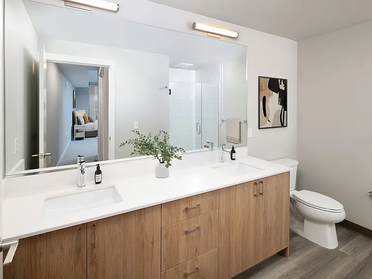 Bath with white quartz countertops, oak cabinetry, and hard surface flooring