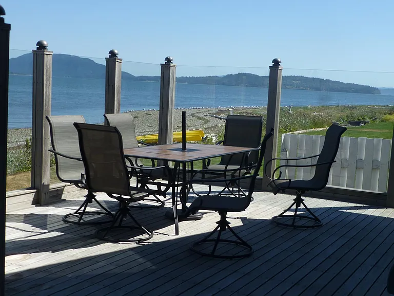 Outdoor dining set comes with umbrella. The glass screen allows outdoor enjoyment on a windy day.