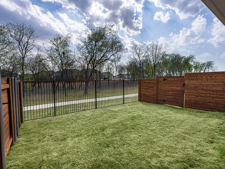 Private fenced backyard with grass perfect for pets.