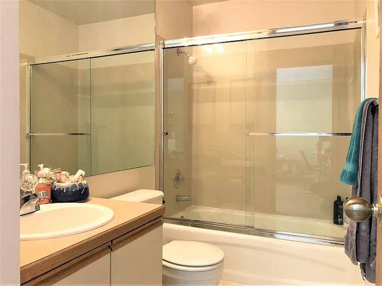 Full size bathroom with tub and shower along with additional storage.