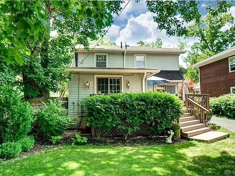 Nice-sized back yard showing deck and stairs.