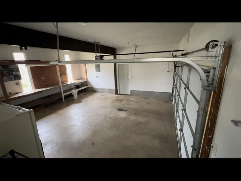 Large two car garage with shelving for storage. Washer and dryer. Second refrigerator in garage.