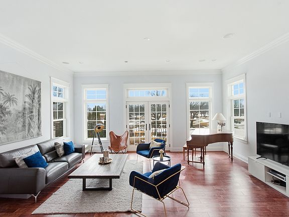 Sunken living room with floor to ceiling windows and door to access patio overlooking golf course
