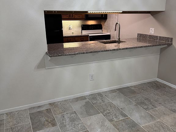 View from dining room into kitchen. Granite counter top with extended bar.