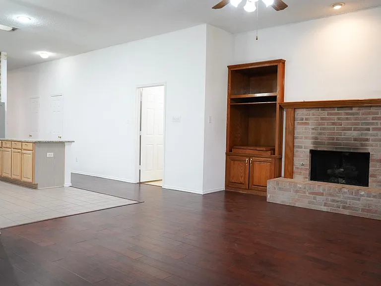 Family room with stone fireplace, built-in shelves.
