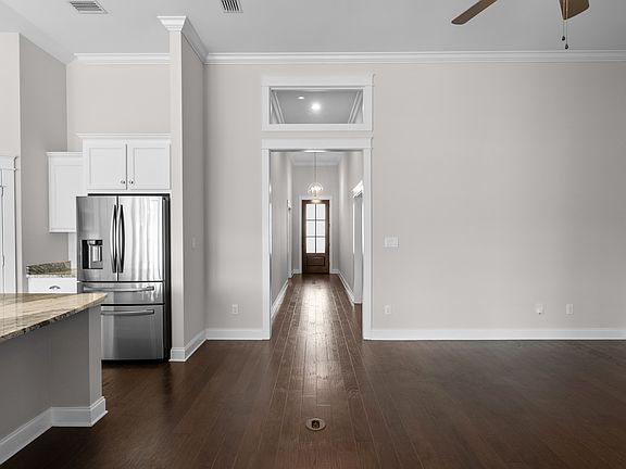 The spacious family room has high ceilings and custom millwork throughout, as well as a gas fireplace, custom dimmable lighting and hardwood floors