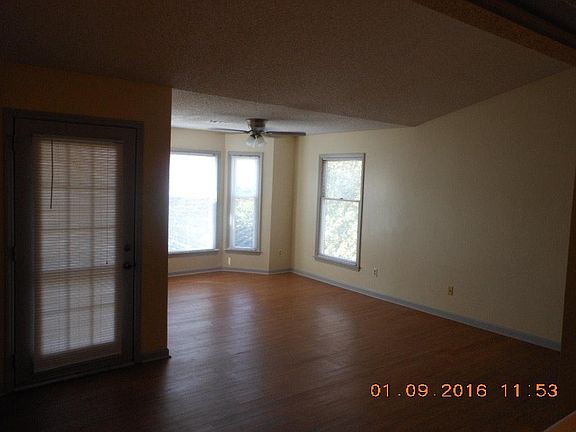 Den with bay window and vaulted ceiling.