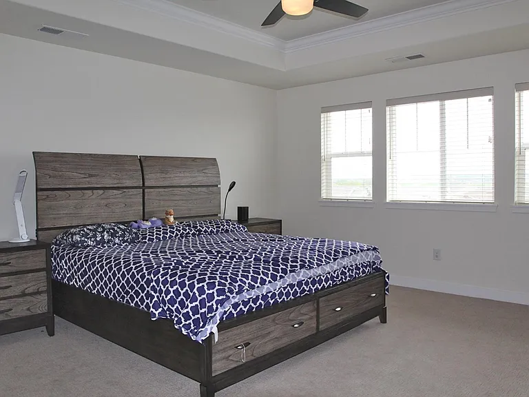 Primary bedroom has tray ceiling and measures 14'8" by 16'