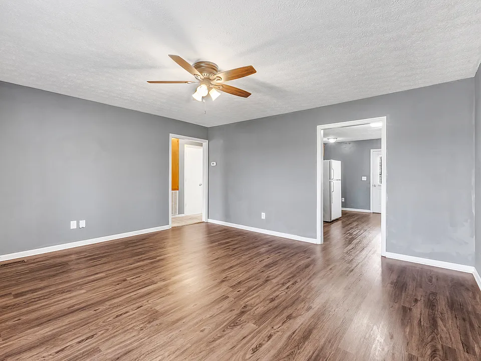 Spacious living room connects to the kitchen (on the right) and the hallway to the bathroom and bedrooms on the left.