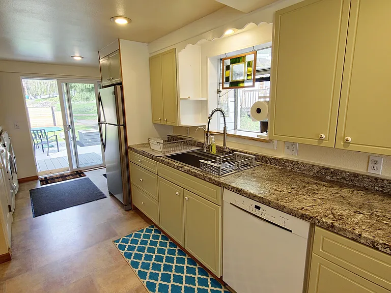 Galley kitchen with new dishwasher, induction range, microwave and numerous accessories.