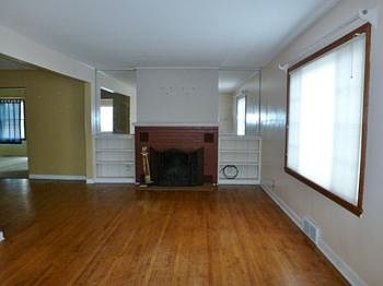 ...and living room with fireplace and large window that keeps the room awash with natural lighting!