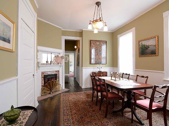 View of the dining room from the living room offering an abundance of natural light and historical details. Rental has been painted neutral colors and is unfurnished.