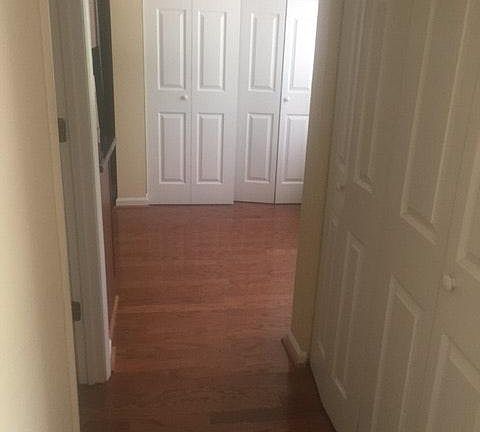 Hallway connecting foyer and kitchen. Half bathroom to left. Washer/dryer behind doors ahead.