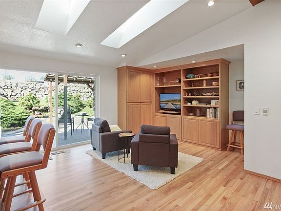 This cozy family room off of the kitchen features a built-in custom media cabinet. Extend your living space outside through a wide slider to the glorious back yard.