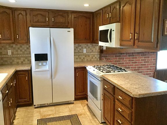 Updated kitchen is attractive with neutral tones and ready for the new owner with newer appliances, new countertops and ceramic flooring.  