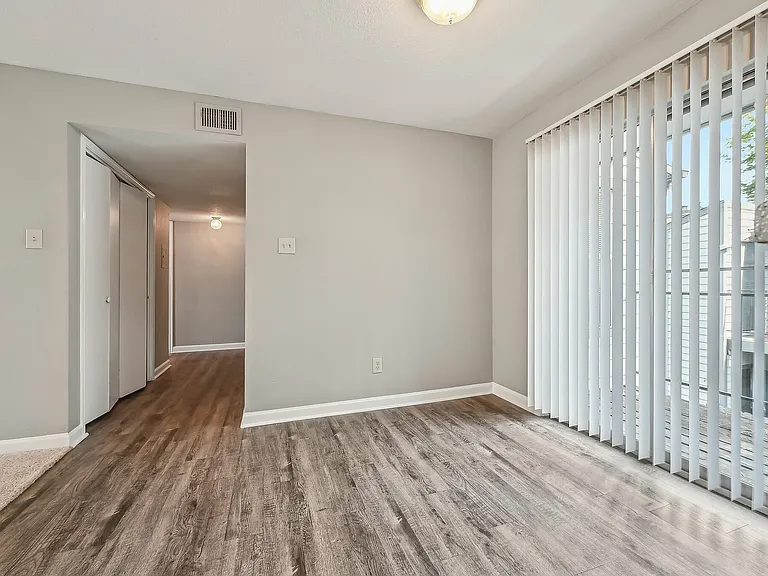 Bright and inviting apartment with sleek hardwood floors and large sliding glass doors leading to a private balcony.