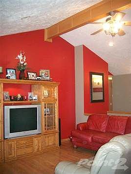 Living Room with high ceiling, oak beam, ceiling fan, and hardwood floors.
