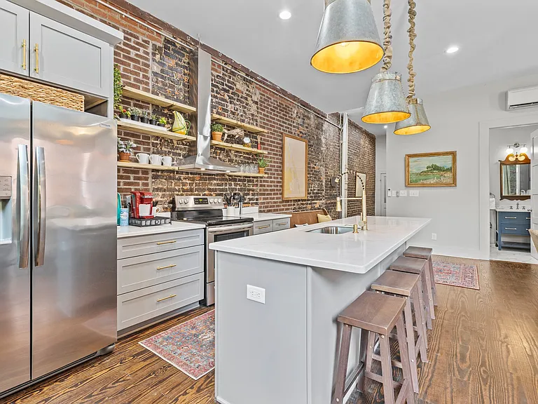 Beautiful, updated kitchen offering open shelving and stainless-steel appliances.