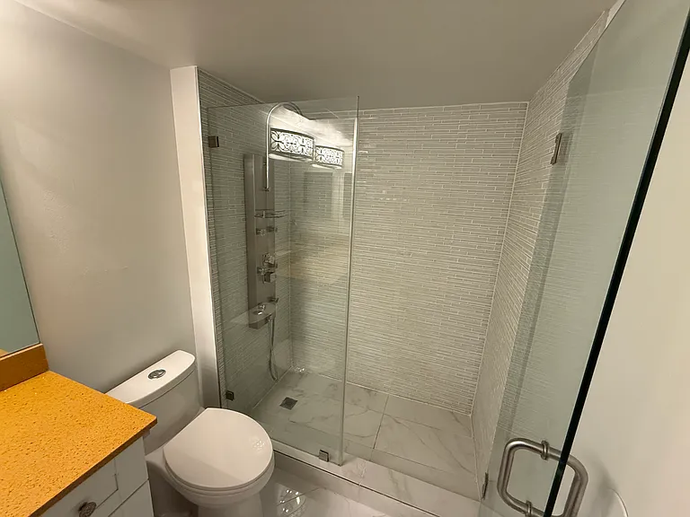 MASTER BATHROOM with limited-edition custom quartz countertop, large vanity mirror, dimmable designer lighting & step-in shower with spa massage jets