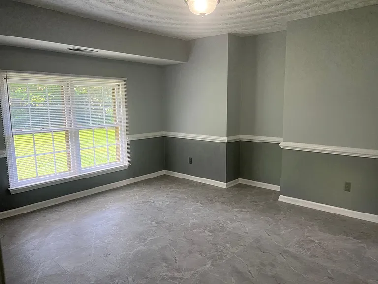 Formal dining room over looks the large back yard. The colors in the picture are deceptive. The walls are light gray with an accent gray below the chair railing.