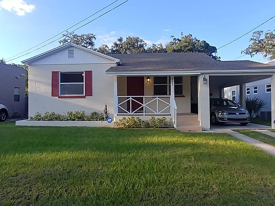Front lawn, porch, carport with laundry.