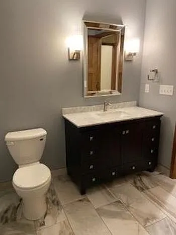 Tiled floor and marble counter vanity.