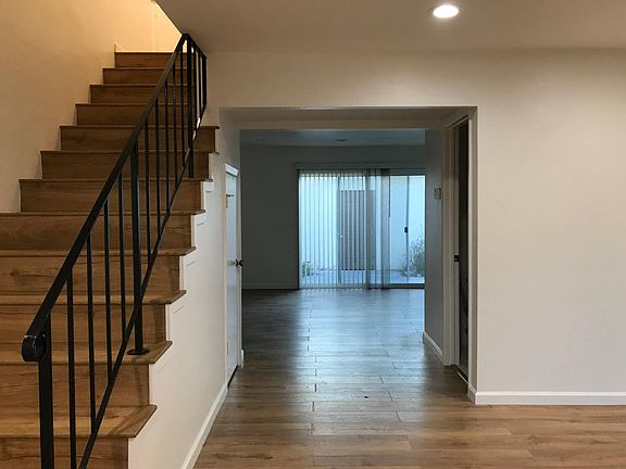 front door entrance with living room to the right and 1/2 bathroom to the right, and dining room straight ahead to back patio with kitchen to the right.